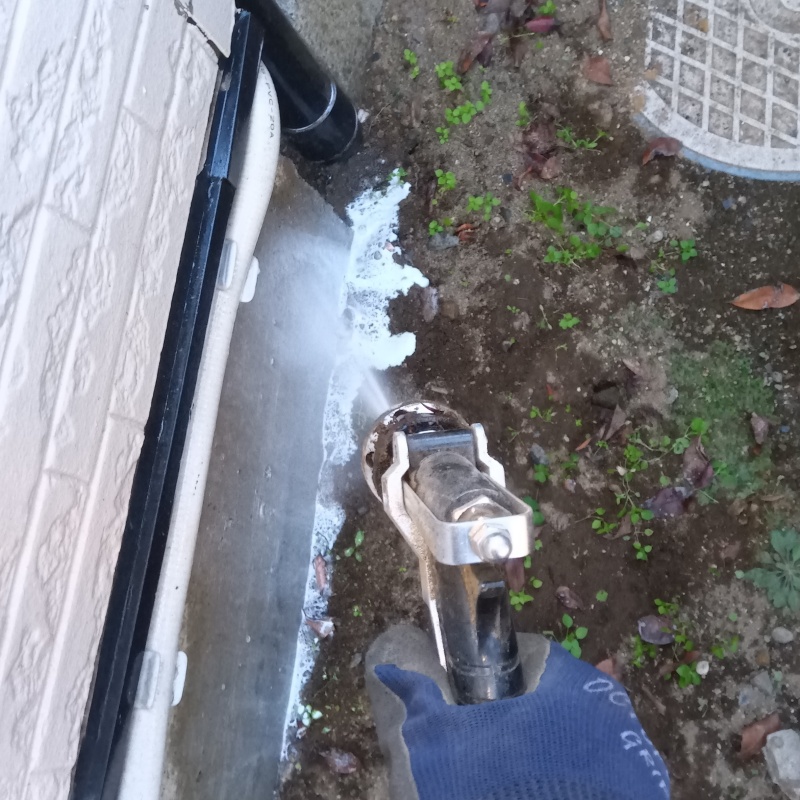 建物外周の土壌にシロアリ駆除剤を吹き付ける様子