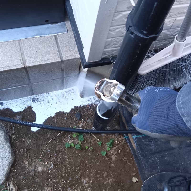 玄関まわりの土壌にシロアリ駆除剤を散布