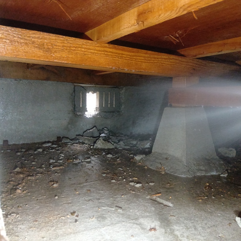 束石まわりに防蟻剤を吹き付けている様子