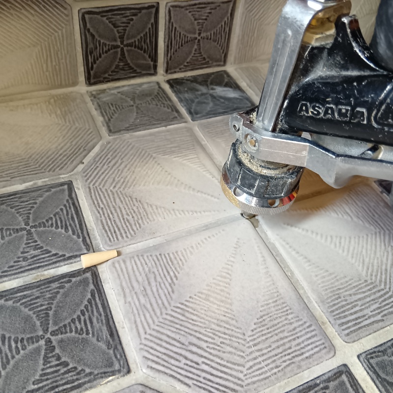 玄関床のタイルの目地に穴を開けて防蟻剤を注入