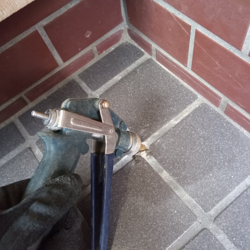 玄関床のタイルの目地からシロアリ駆除剤を注入