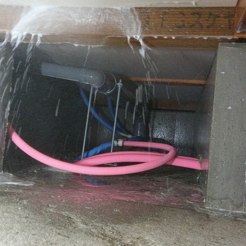 床下の木材に防蟻剤を吹き付ける様子