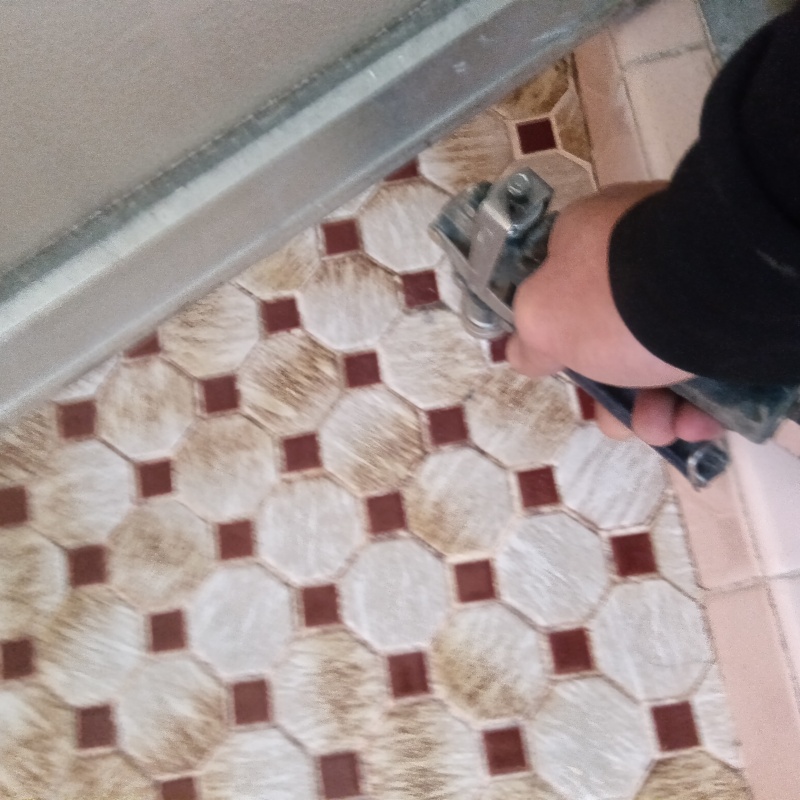 玄関床のタイルの目地に穴を開けてシロアリ駆除剤を注入