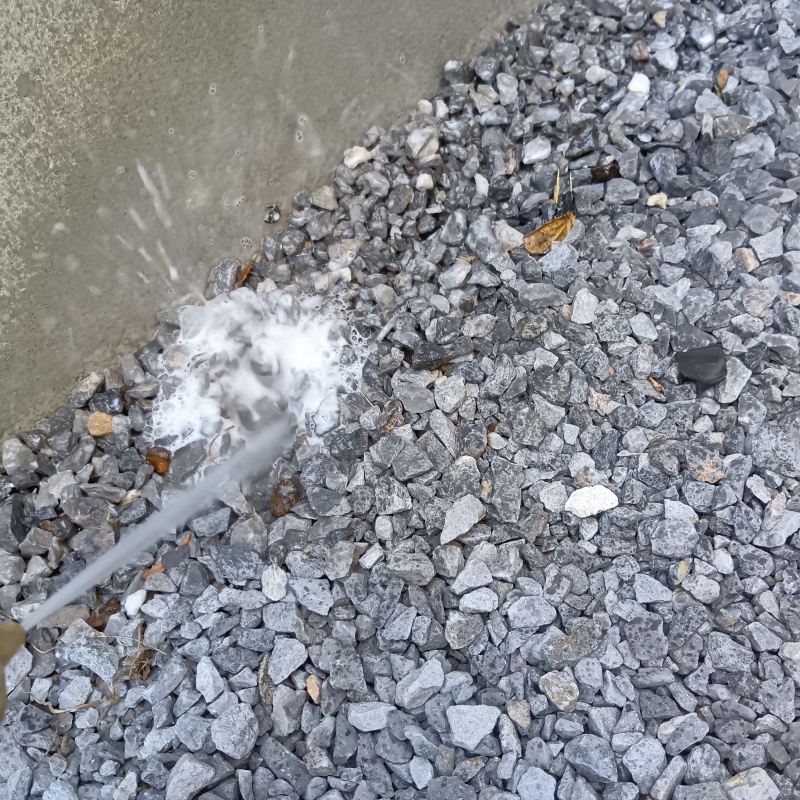 建物外周の土壌に防蟻剤を吹きつける様子