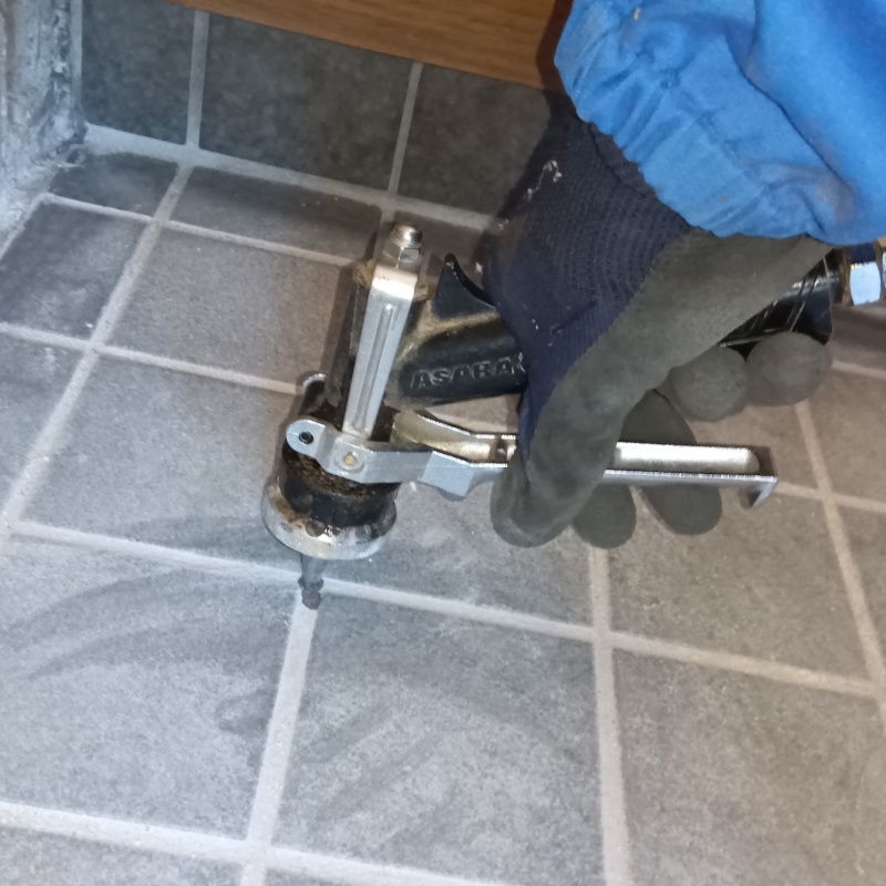 玄関床のタイルの目地に穴を開けてシロアリ駆除剤を注入