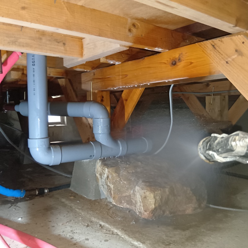 束石に防蟻剤を吹きつけている様子