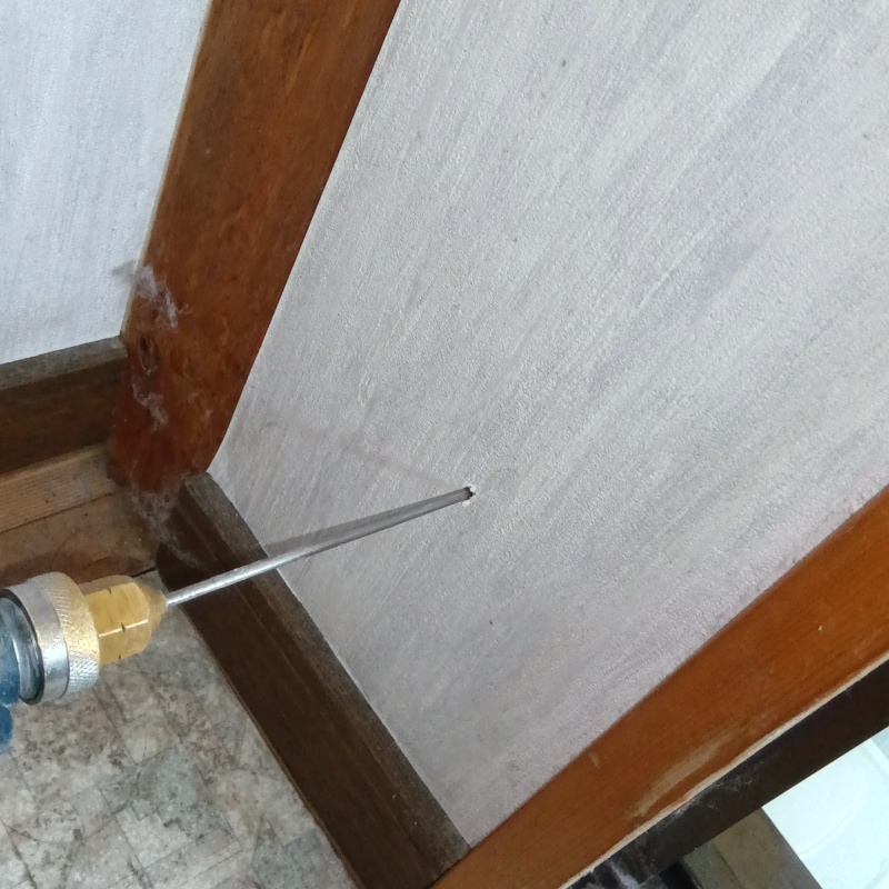 壁に穴を開けて防蟻剤を注入している様子