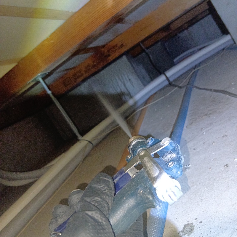 床下基礎のコンクリートに防蟻剤を吹きつけている様子