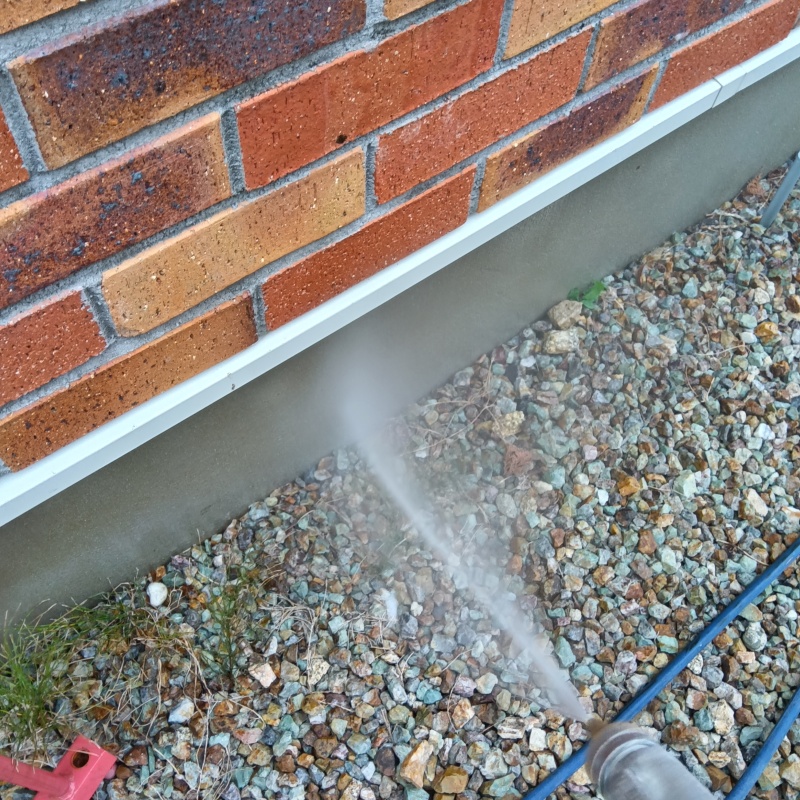 屋外の地面にシロアリ駆除剤を散布