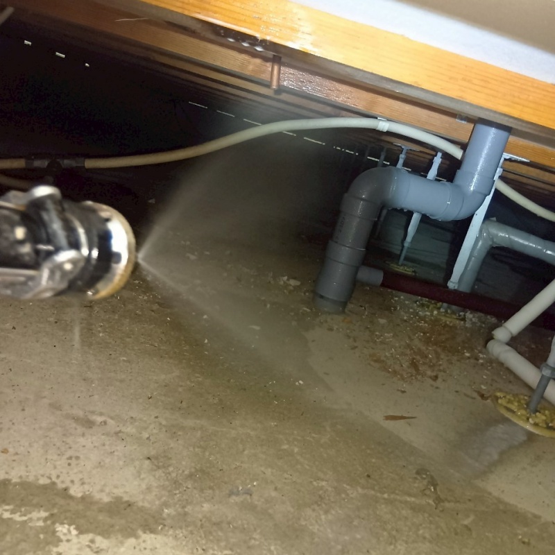 床下木材に防蟻剤を吹き付ける様子