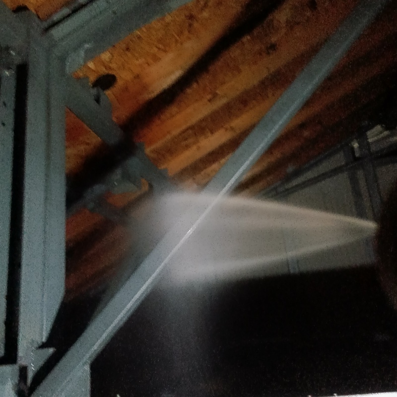 屋根裏の木材にシロアリ駆除剤を吹き付けている様子