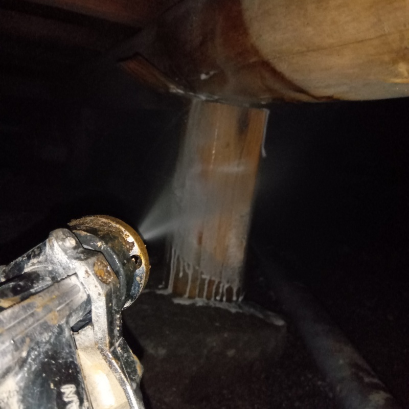 床下木材にシロアリ駆除剤を吹き付ける様子