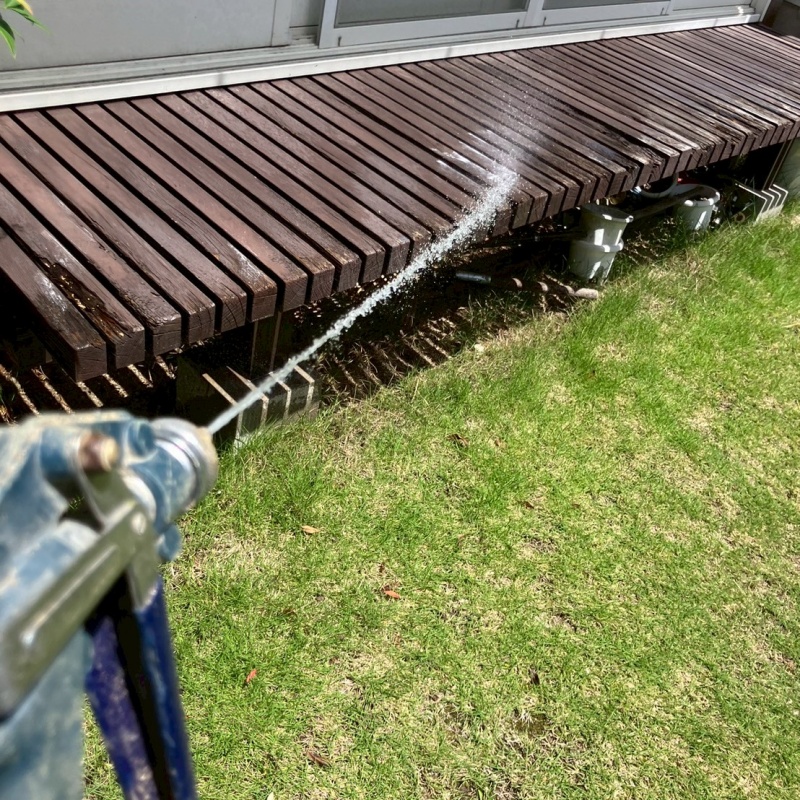 ウッドデッキに防蟻剤を吹き付けている様子