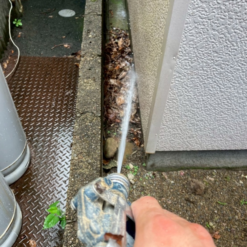 建物外周の土壌にシロアリ駆除剤を吹き付ける様子