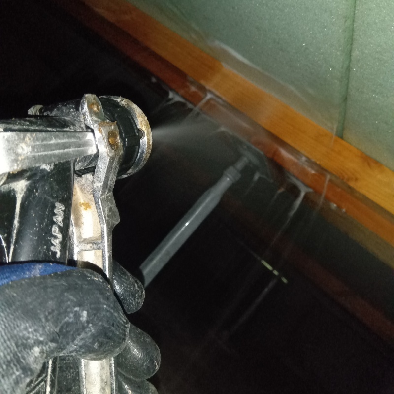 床下断熱材にシロアリ駆除剤を吹き付ける様子