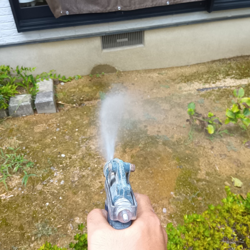 建物外周の土壌にシロアリ駆除剤を吹き付ける様子