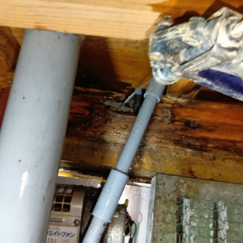 床下木材に防蟻剤を吹き付ける様子