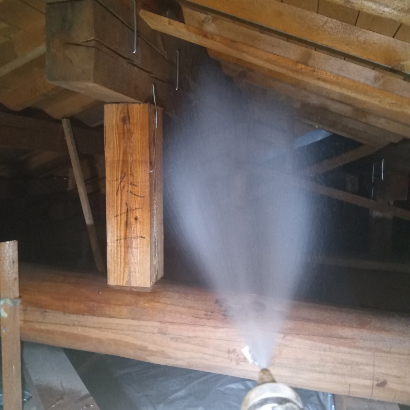 屋根裏の木材にシロアリ駆除剤を散布