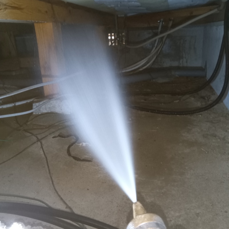 床下木材にシロアリ駆除剤を吹き付けている様子