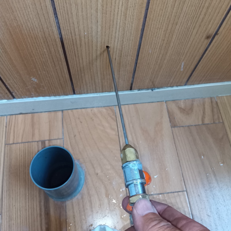 木製の壁材に穴を開けてシロアリ駆除剤を注入