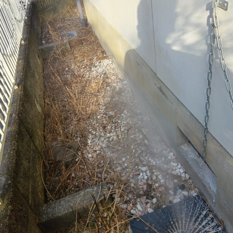 建物外周の土壌にシロアリ駆除剤を吹き付ける様子