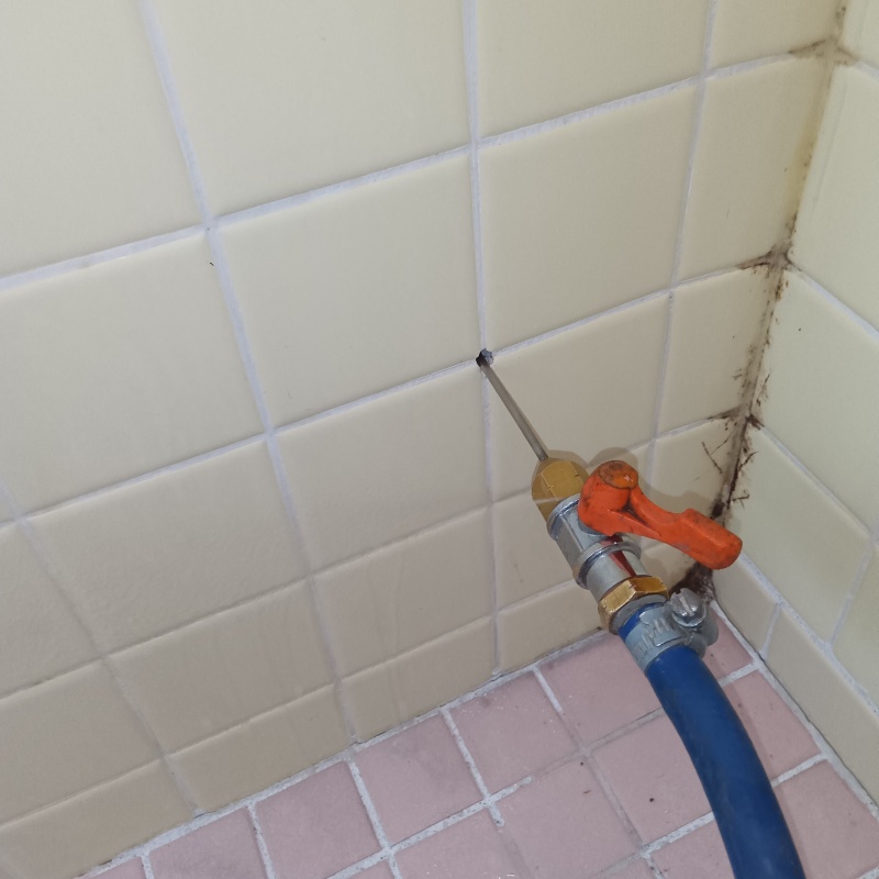 浴室壁の目地からシロアリ駆除剤を注入