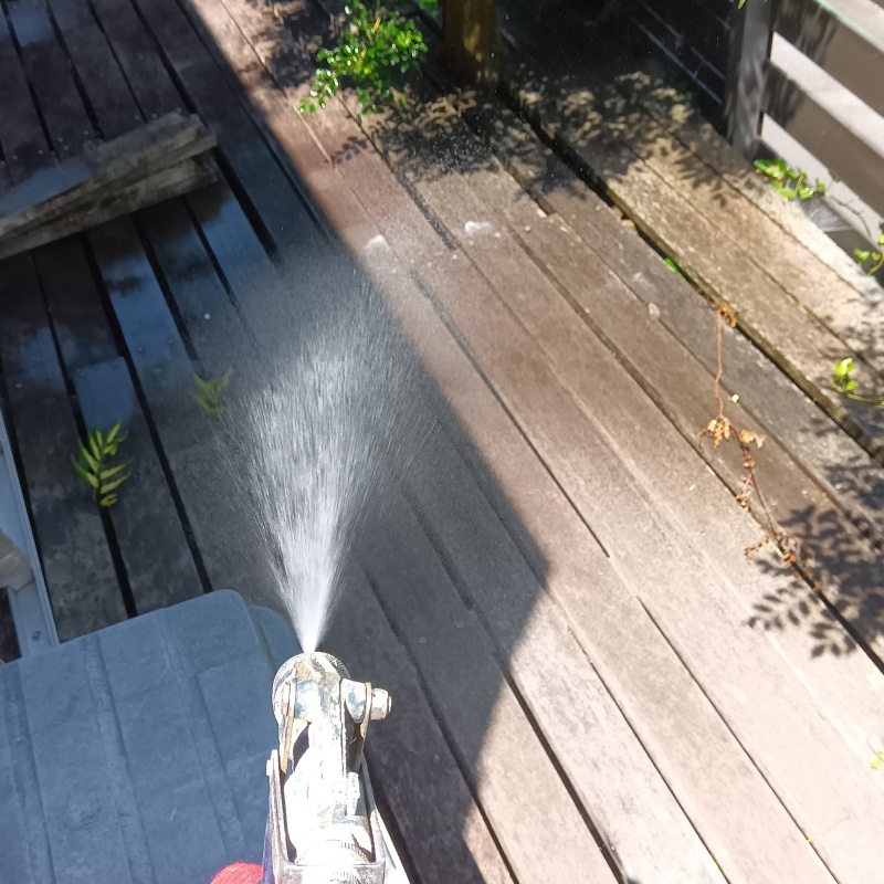 ウッドデッキにシロアリ駆除剤を吹き付ける様子