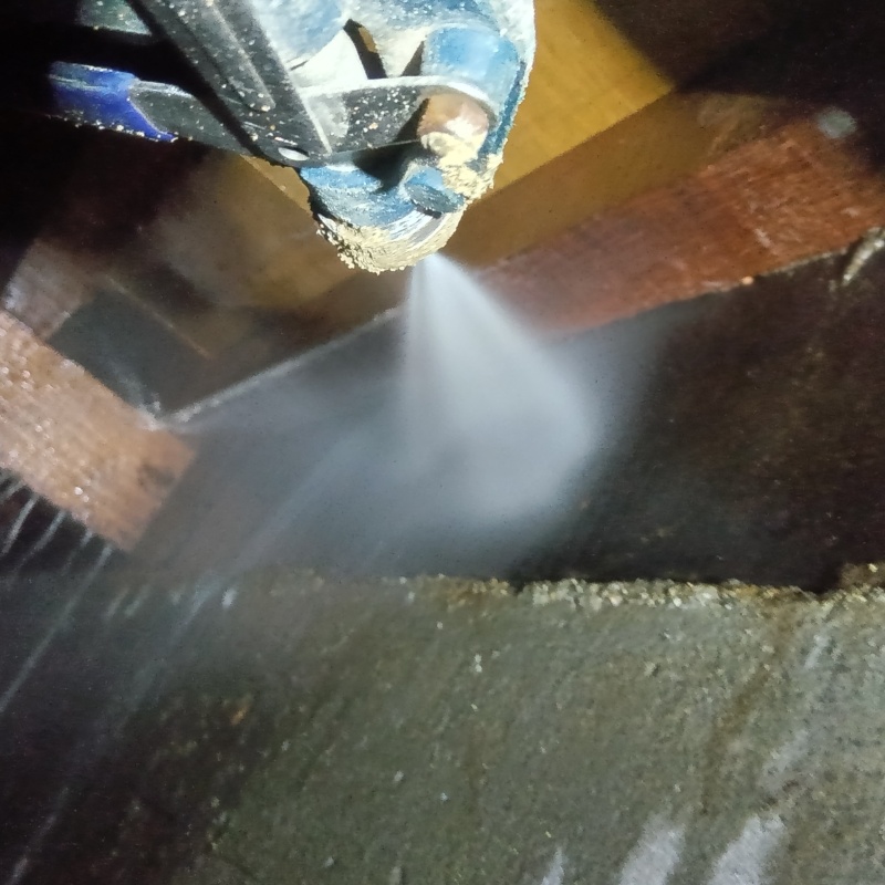 床下木材にシロアリ駆除剤を吹き付ける様子