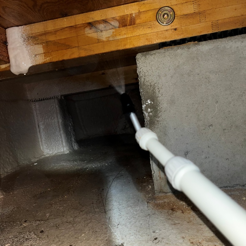 床下木材に防蟻剤を吹き付ける様子