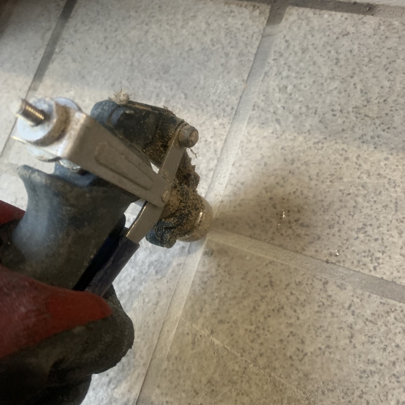 玄関の床にシロアリ駆除剤を注入する様子