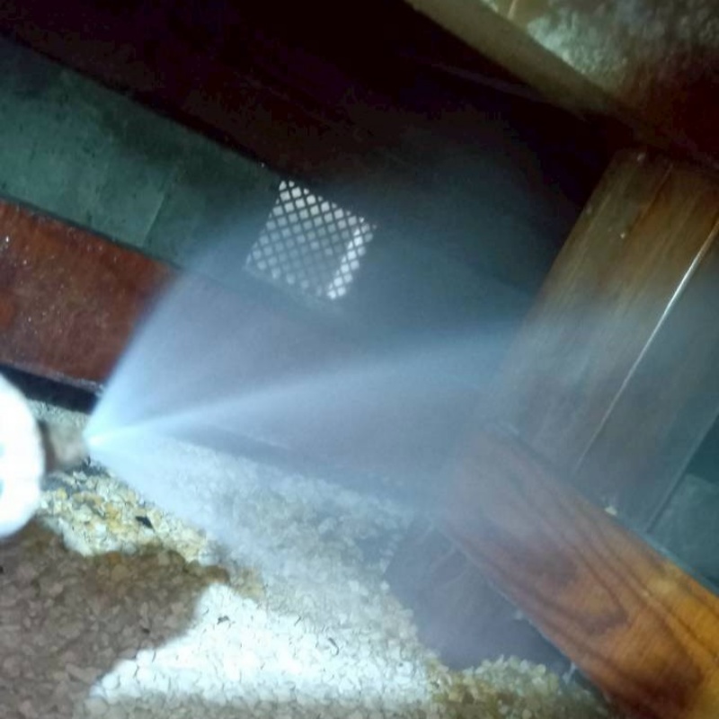 床下の木材にシロアリ駆除剤を散布する様子