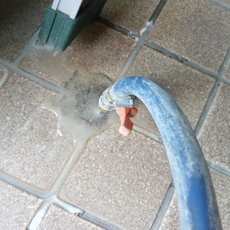 玄関の床にシロアリ駆除剤を注入する様子