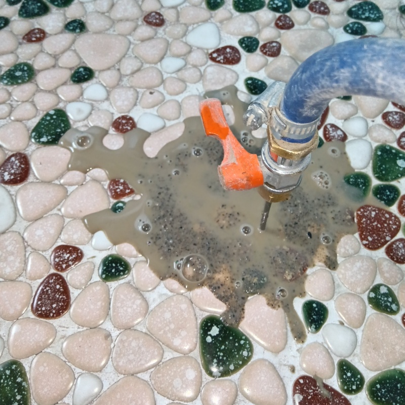 浴室の床にシロアリ駆除剤を注入する様子