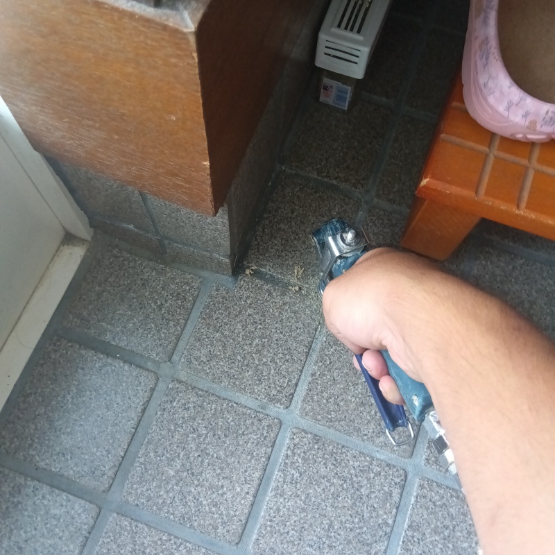 玄関の床に防蟻剤を注入する様子