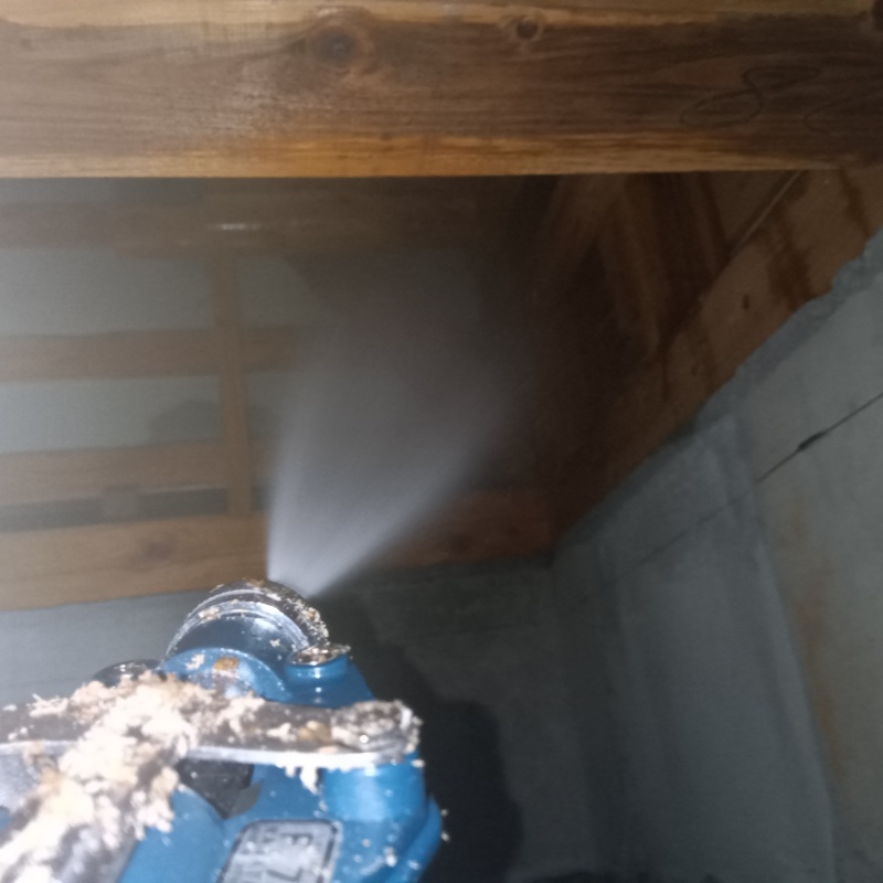 床下の木材にシロアリ駆除剤を散布する様子