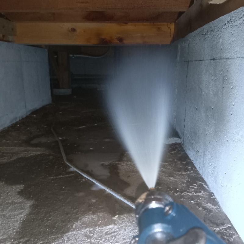 床下の土壌にシロアリ駆除剤を散布する様子