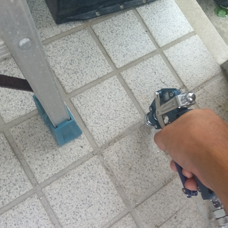 玄関の床にシロアリ駆除剤を注入する様子
