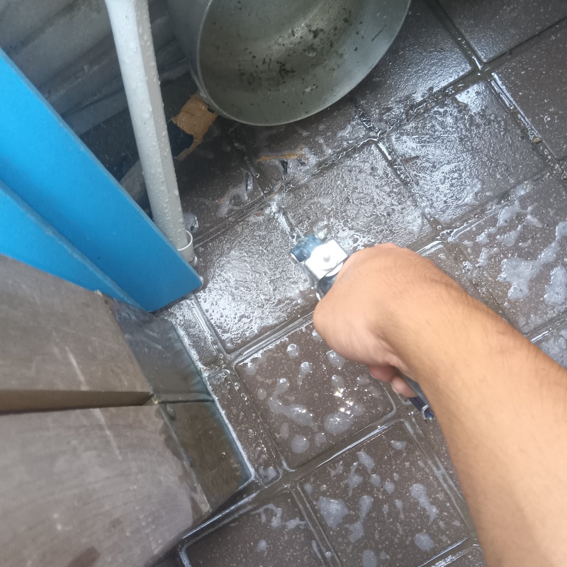 玄関の床にシロアリ駆除剤を注入する様子