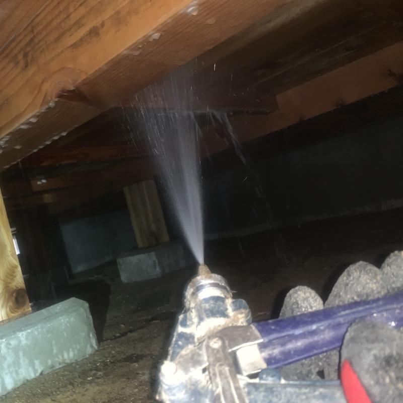 床下の木材にシロアリ駆除剤を散布する様子