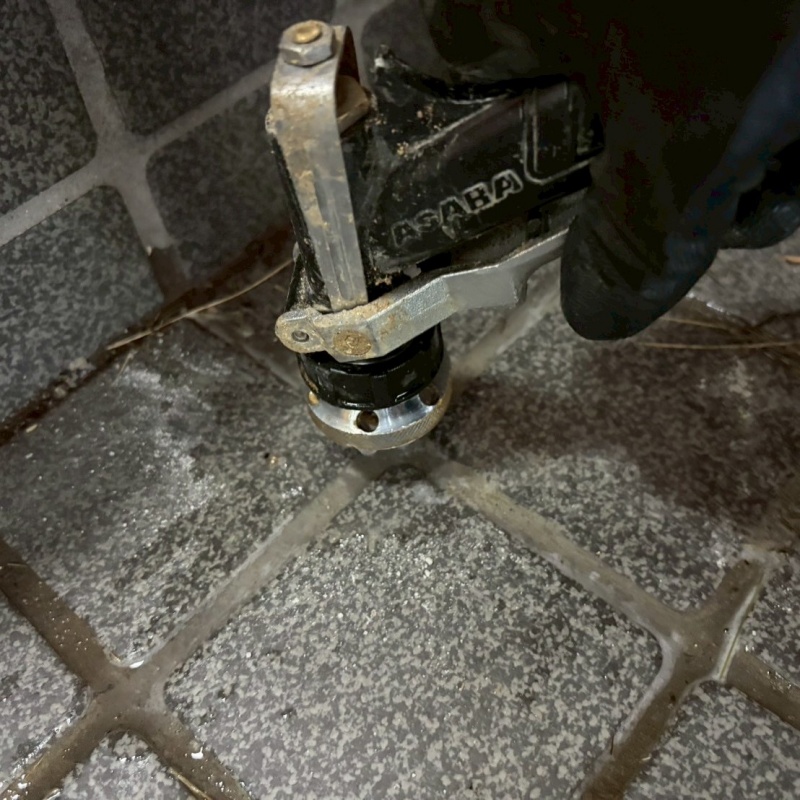 玄関の床にシロアリ駆除剤を注入する様子