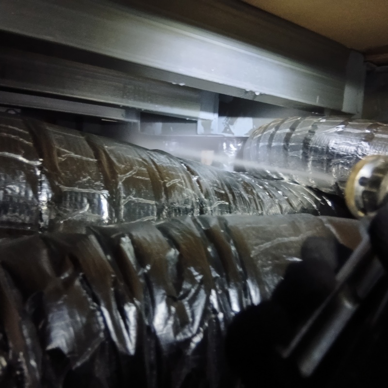 床下の基礎部分に防蟻剤を散布する様子