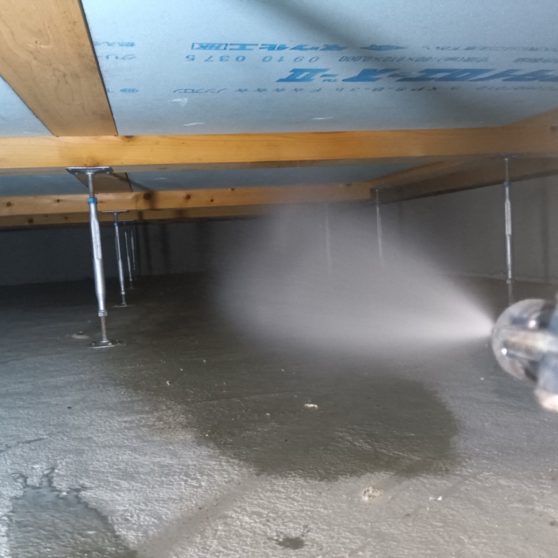 床下の土壌に防蟻剤を散布する様子