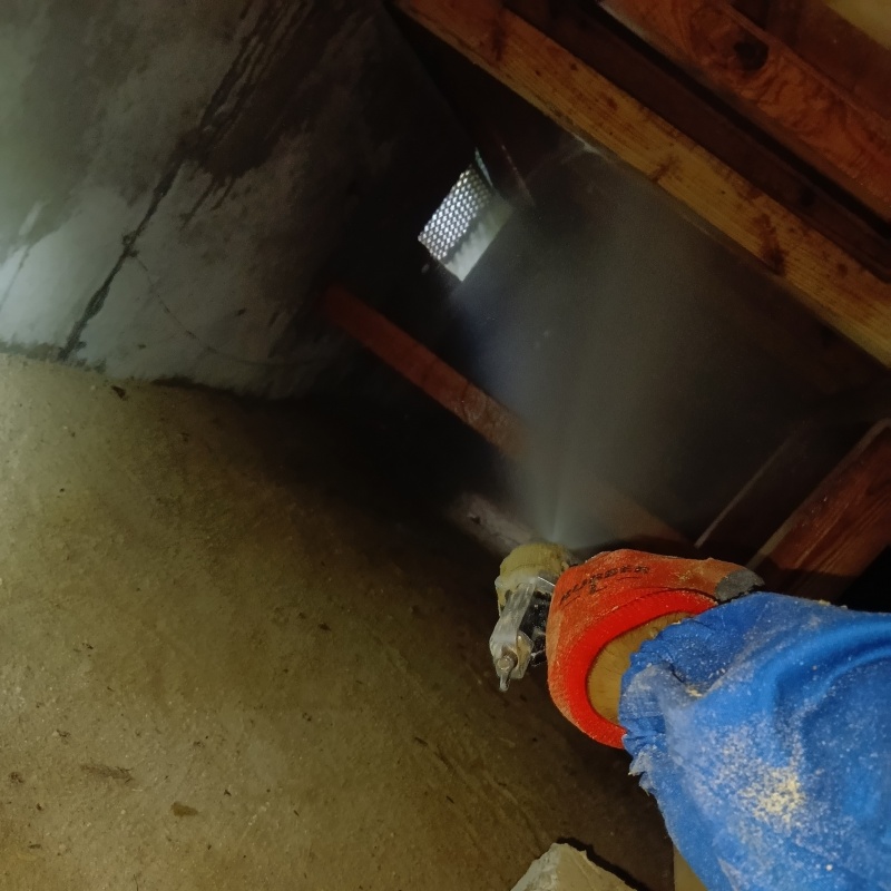 床下の木材にシロアリ駆除剤を散布する様子