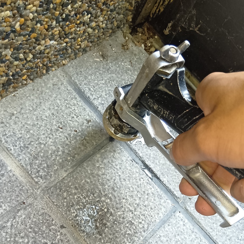 玄関の床にシロアリ駆除剤を注入する様子