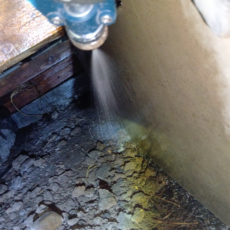 床下の土壌に防蟻剤を散布する様子