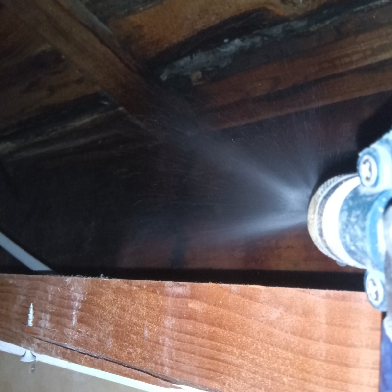 床下の木材にシロアリ駆除剤を散布する様子