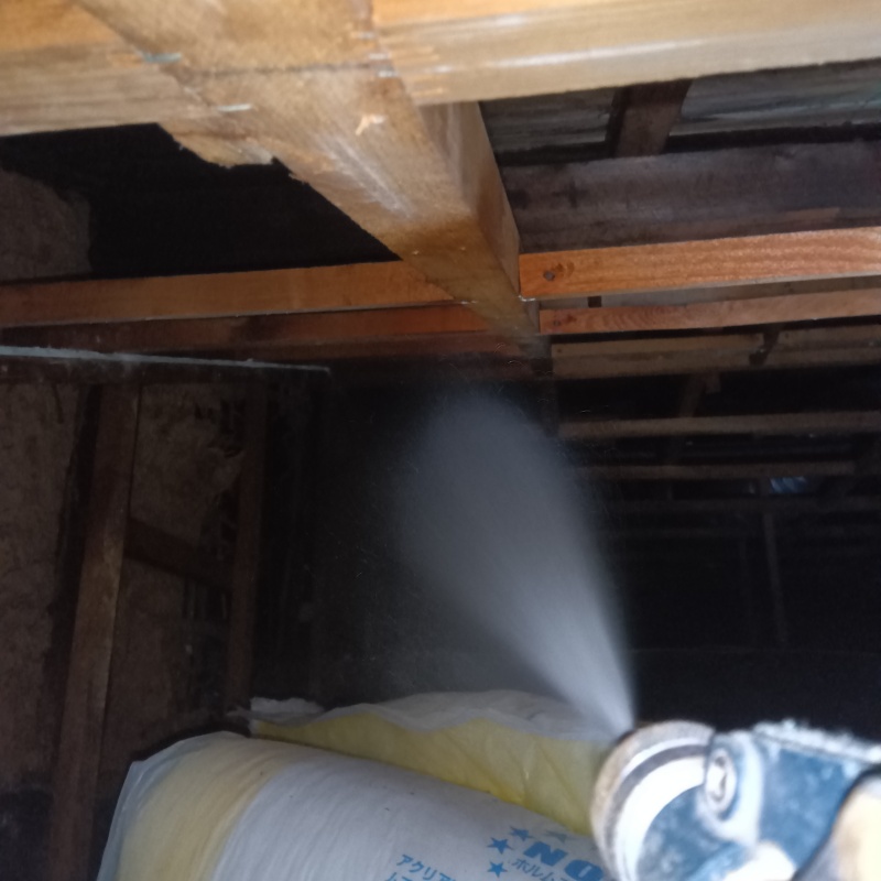 床下の木材にシロアリ駆除剤を散布する様子