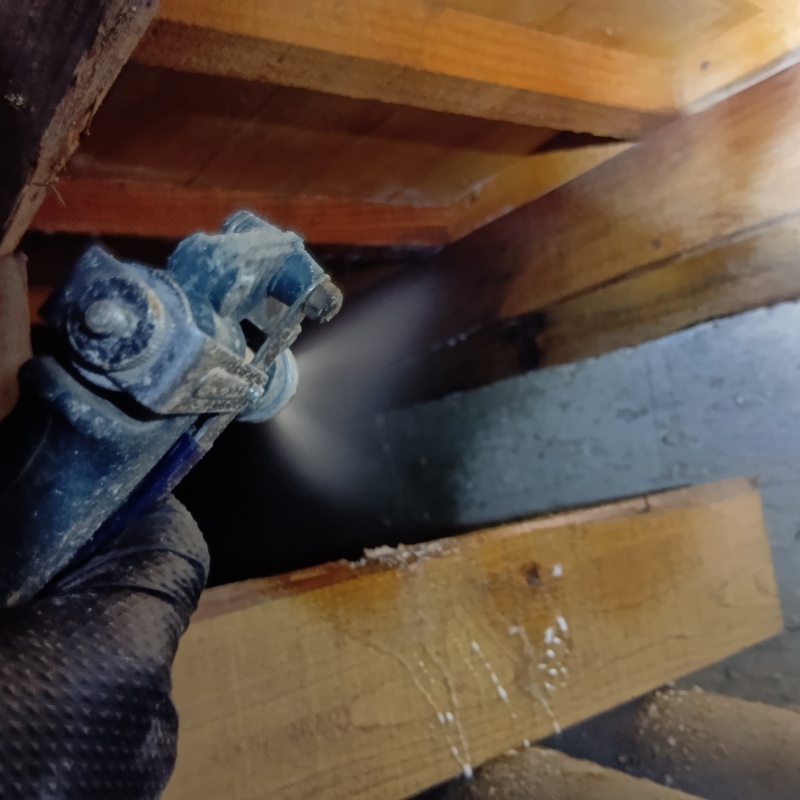 床下の木材にシロアリ駆除剤を散布する様子