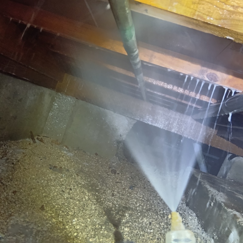 床下の木材にシロアリ駆除剤を散布する様子