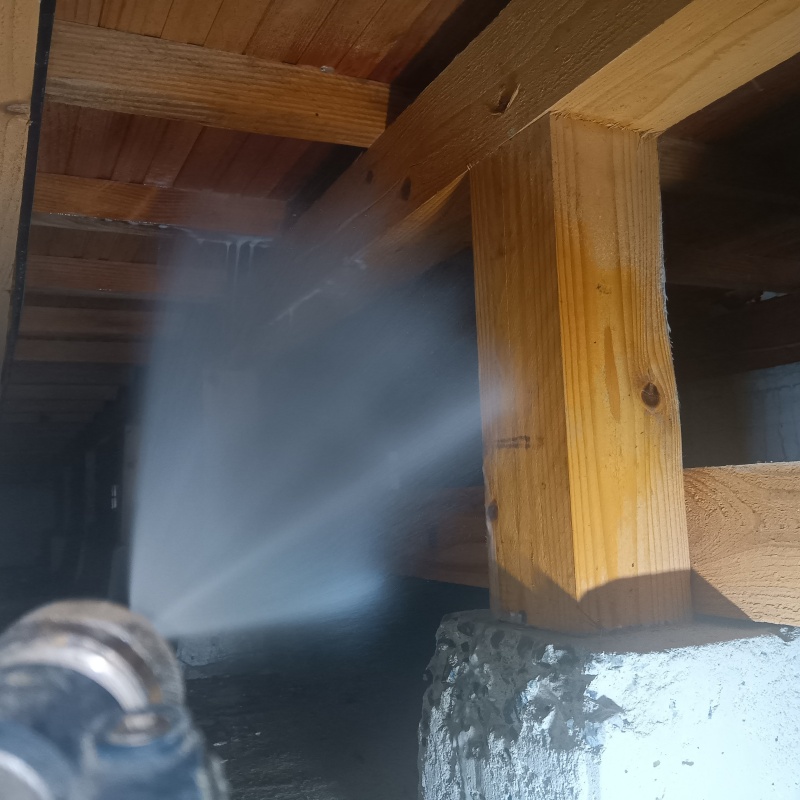 床下の木材に防蟻剤を散布する様子